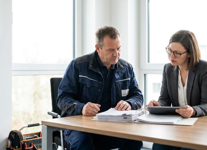 Elektriker bespricht Vertragsunterlagen mit einem Berater